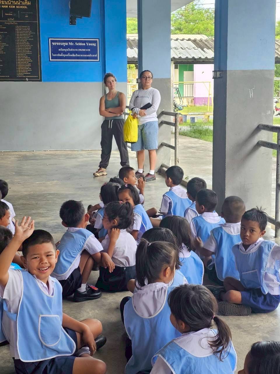 Students in blue smocks with interns