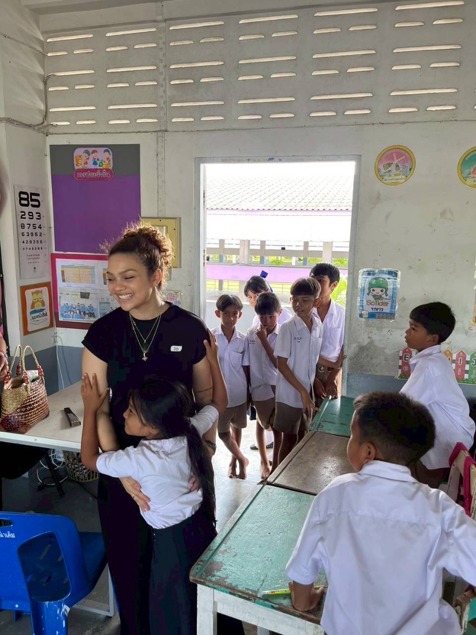 Student hugging intern in a classroom